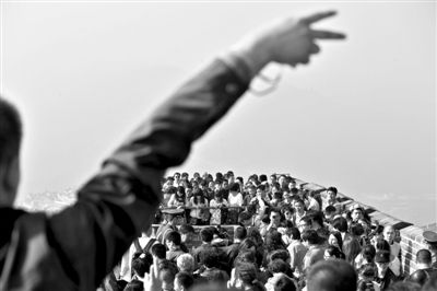 10月4日，游客在好漢坡上擺手勢拍照留念，背景是如織的人流。新京報記者 周崗峰 攝