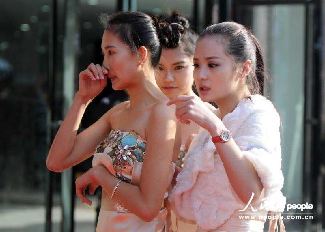 2013年11月16日9時，在江西九江一車展現(xiàn)場，寒風中穿著露肩禮服的禮儀小姐凍得只打噴嚏。CFP/CFP