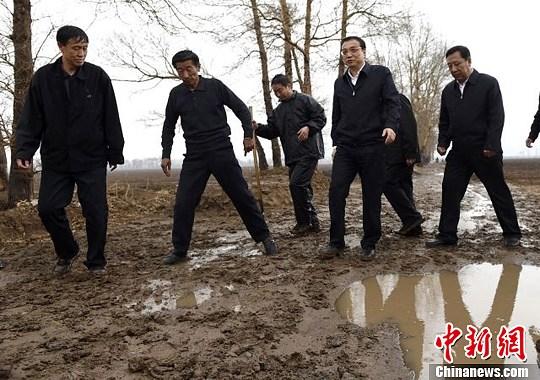 李克強(qiáng)雨中田間察看 拿鐵鍬翻泥土(圖)