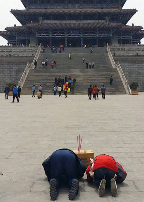 男子在燒香跪拜求升官。