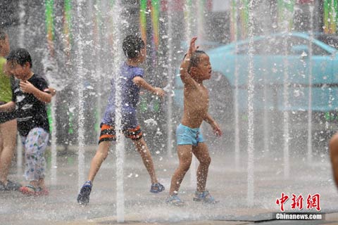 7月20日，北京天氣炎熱，孩子們在噴泉中嬉水納涼。