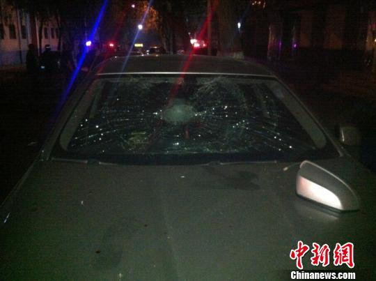 圖為一輛轎車的倒車鏡和前擋風(fēng)玻璃被砸。　胡貴龍攝