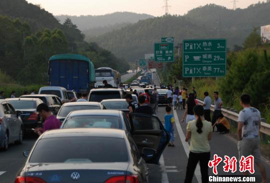 圖為梅河高速段出現(xiàn)擁堵司機(jī)及乘客都紛紛下車“休息”。　顏新陽攝