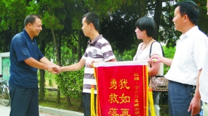 獲救少年家屬給“的哥”馬俊麟送錦旗。