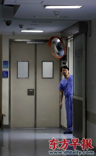 4月15日晚，一名醫(yī)生在救治中毒學(xué)生的中山醫(yī)院重癥監(jiān)護室內(nèi)向外張望。 早報記者孫湛圖