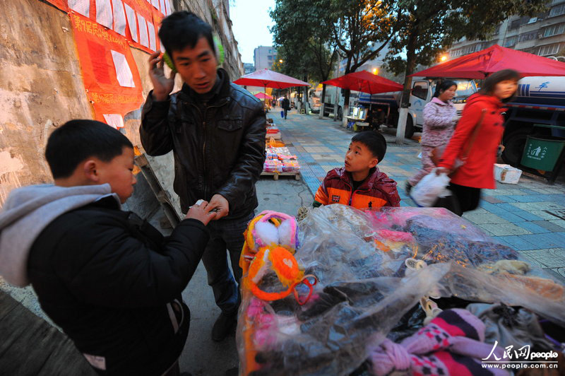 傍晚6時19分，一個顧客花4塊錢買走了一個耳套，李鴻昆在一邊連問：“叔叔，熱和不？”CFP