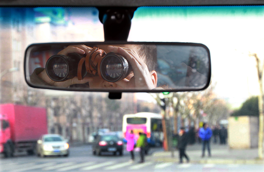 反扒隊員李某在用望遠鏡觀察公交車站情況（1月16日攝）。新華社記者 凡軍 攝