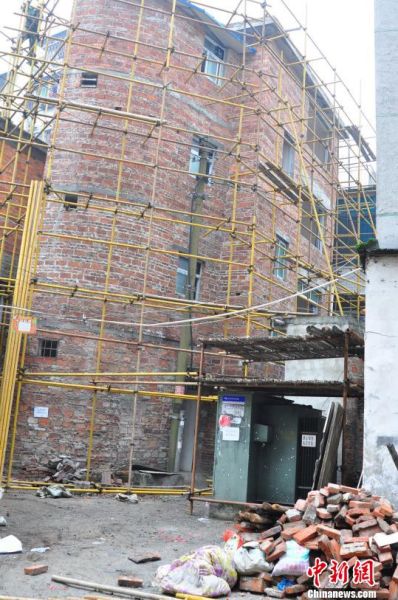 傾斜樓房的四周搭上了鋼架。 周瀟男 攝
